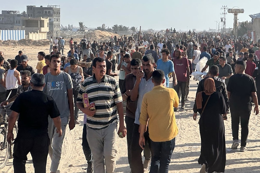 فلسطينيون يحاولون الحصول على مساعدات غذائية في مواقع توزيع في قطاع غزة - 27 أيار/مايو 2025 (أ ف ب)