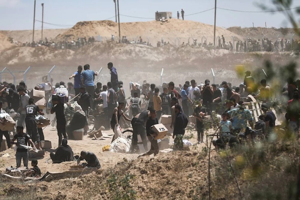 فلسطينيون يحملون مساعدات إغاثية تلقوها من مؤسسة 