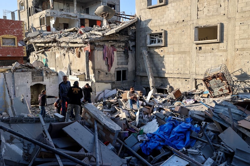 فلسطينيون يبحثون عن ناجين بين أنقاض مبنى تدمر في غارة إسرائيلية على مخيم البريج للاجئين وسط قطاع غزة - 2 أيار/مايو 2025 (أ ف ب)