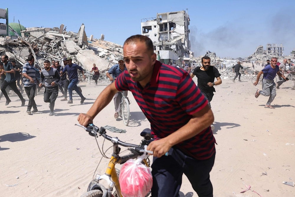 فلسطينيون يركضون بعد غارة جوية إسرائيلية بطائرة بدون طيار على جباليا شمال قطاع غزة (أ ف ب)