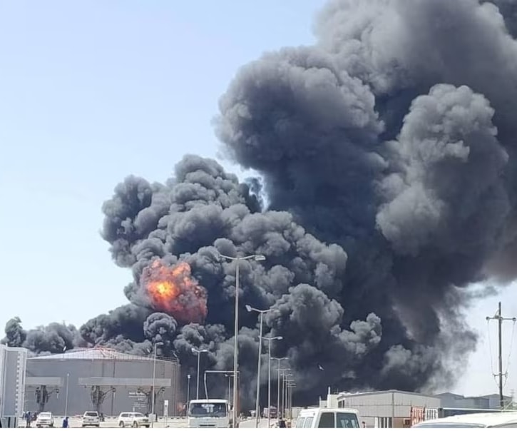 دخان ونيران تتصاعد من مستودع وقود بعد هجوم بمسيّرة نفّذته قوات الدعم السريع في بورتسودان في السودان (رويترز)