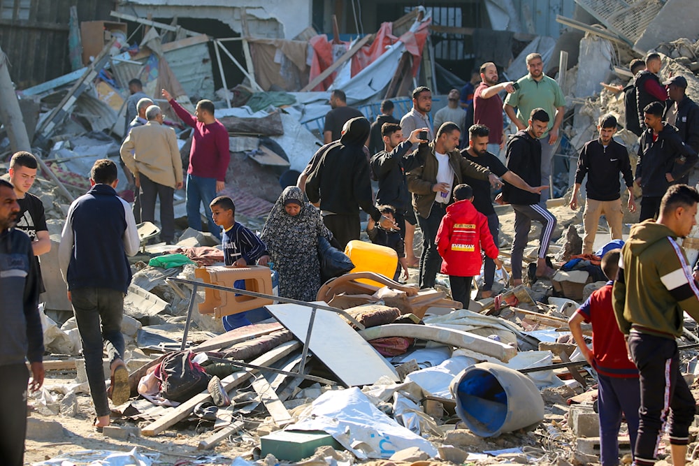 فلسطينيون يتفقدون الدمار بعد غارة إسرائيلية على مخيم البريج للاجئين في وسط قطاع غزة - 7 أيار/مايو 2025 (أ ف ب)