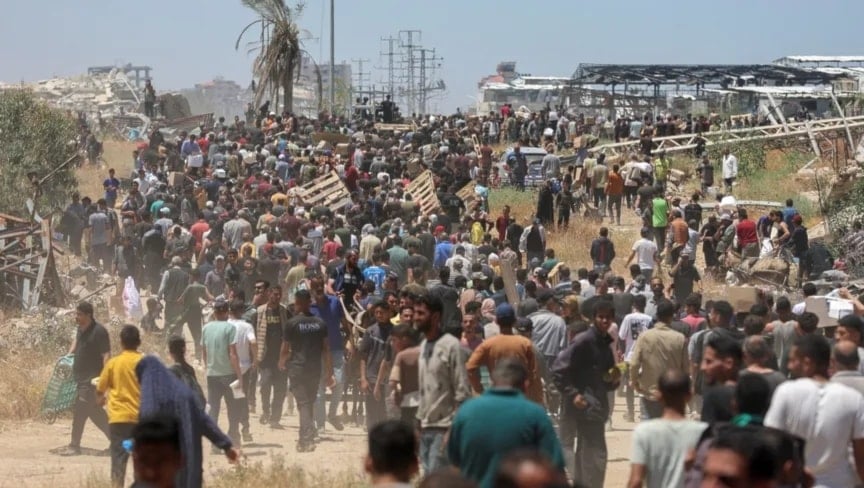 فلسطينيون يتجمعون قرب مركز لتوزيع المساعدات الغذائية وسط غزة، 29 أيار/مايو 