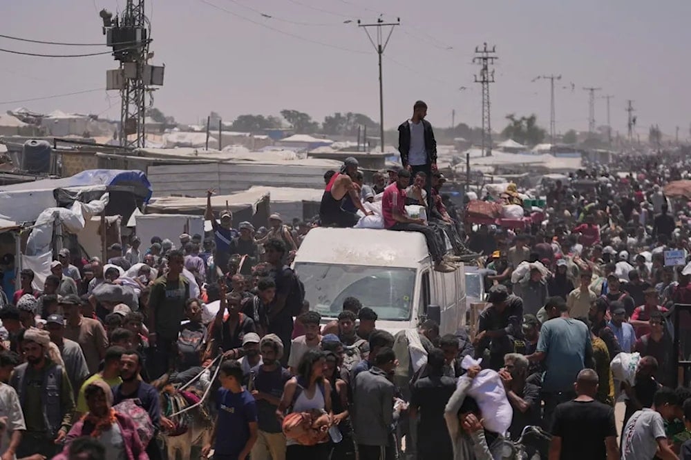 فلسطينيون يحملون أكياساً تحتوي على مساعدات غذائية وإنسانية في رفح جنوب قطاع غزة (أ ب)