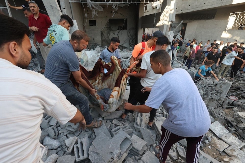 فلسطينيون ينقلون مصاباً انتُشل من تحت أنقاض منزلٍ استُهدف في غارة إسرائيلية على مخيم النصيرات وسط قطاع غزة، في 15 يونيو/حزيران 