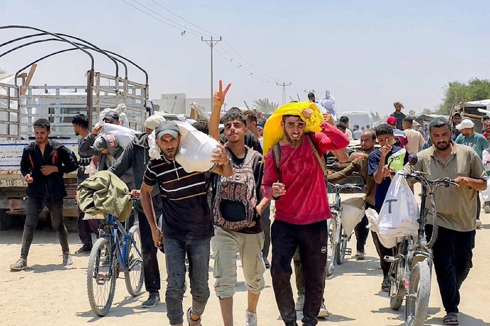فسطينيون مهجرون قسراً يتلقون مساعدات إنسانية في رفح جنوبي قطاع غزّة (أ ف ب)
