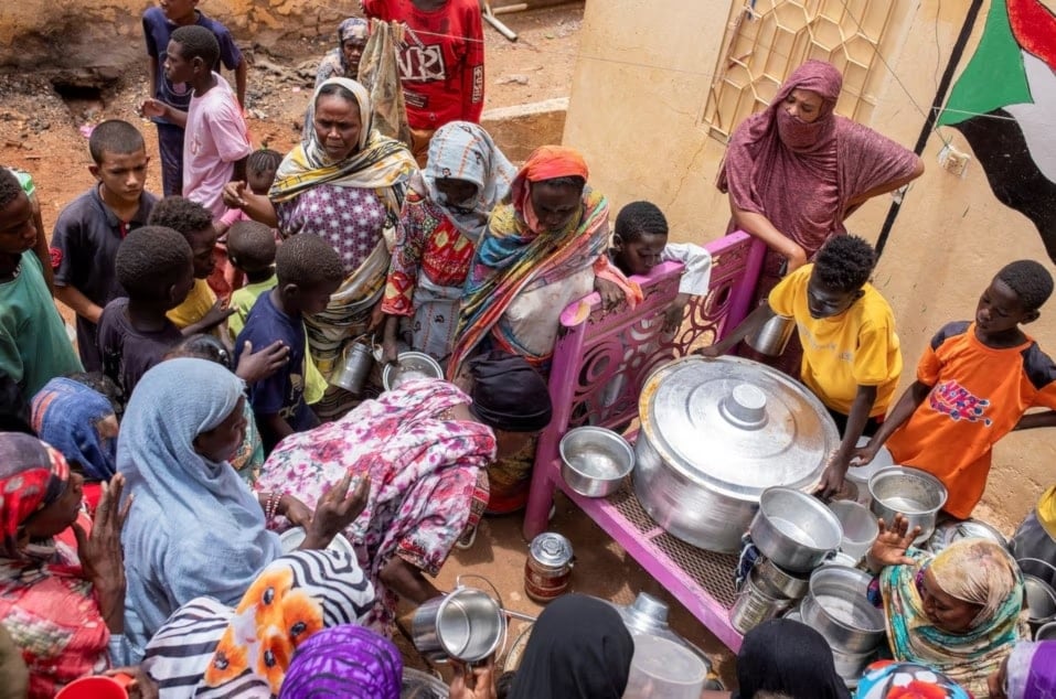 نساء سودانيات يوزعن وجبات الطعام على المتضررين الذين هم خارج نطاق جهود الإغاثة الدولية في أم درمان بالسودان (رويترز)