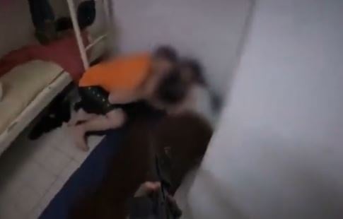 صورة تظهر توجيه أحد جنود الاحتلال السلاح على سجناء فلسطينيين في أحد السجون قبل تكبيلهم ونقلهم بسبب احتفالهم بضربات إيران