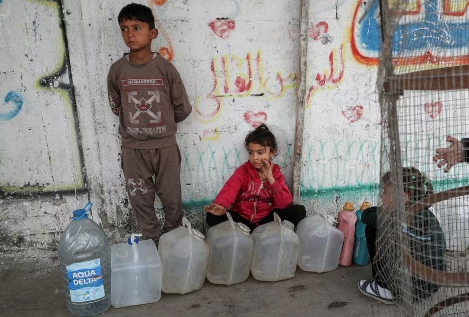 أطفال فلسطينيون يتجمعون قرب حاويات المياه. مدينة غزة. 6 نيسان/أبريل 2025. (رويترز)