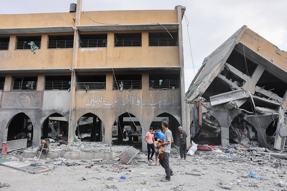 فلسطينيون بين أنقاض مدرسة يافا التي قصفها الاحتلال الإسرائيلي في حي التفاح في مدينة غزة (أ ف ب)
