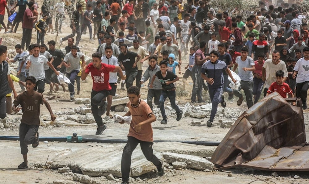 فلسطينيون يتجمعون لاستلام المساعدات الإنسانية في خان يونس جنوبي قطاع غزة (الأناضول)