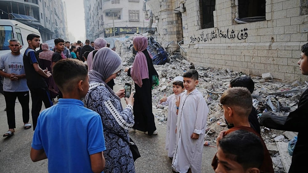 فلسطينيون يتجمعون بعد صلاة عيد الأضحى بجانب أنقاض مسجد الكنز الذي دمره القصف الإسرائيلي في مدينة غزة (أ ب)
