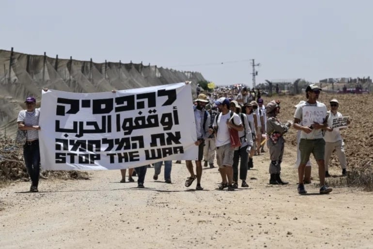  مجموعة من الناشطين مسيرة للمطالبة بوقف الهجمات الإسرائيلية على قطاع غزة، وإطلاق سراح الأسرى، في 6 حزيران/يونيو 2025، في مستوطنة 