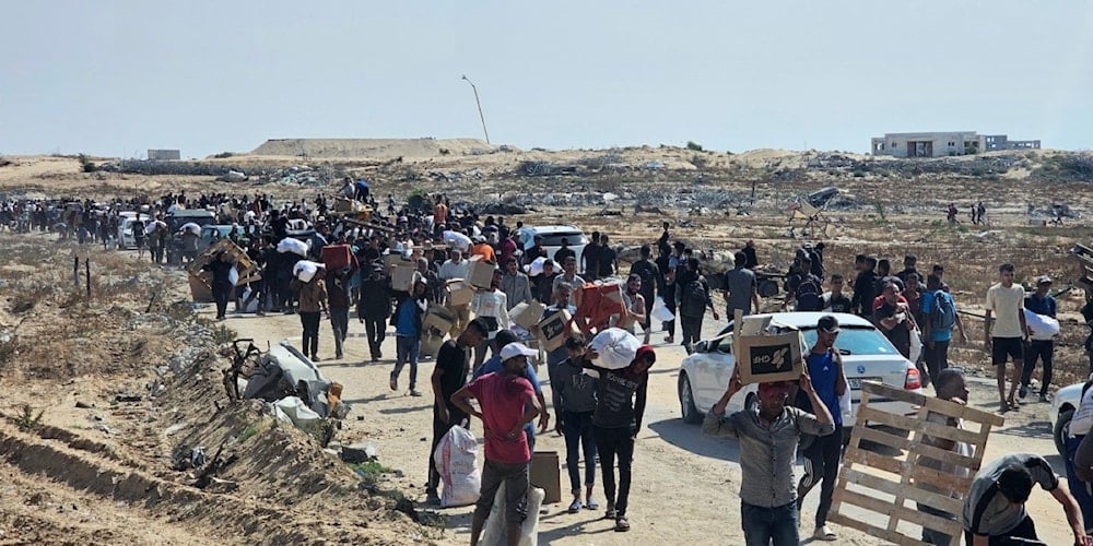 فلسطينيون نازحون يسيرون على طول الطريق لتلقي 
