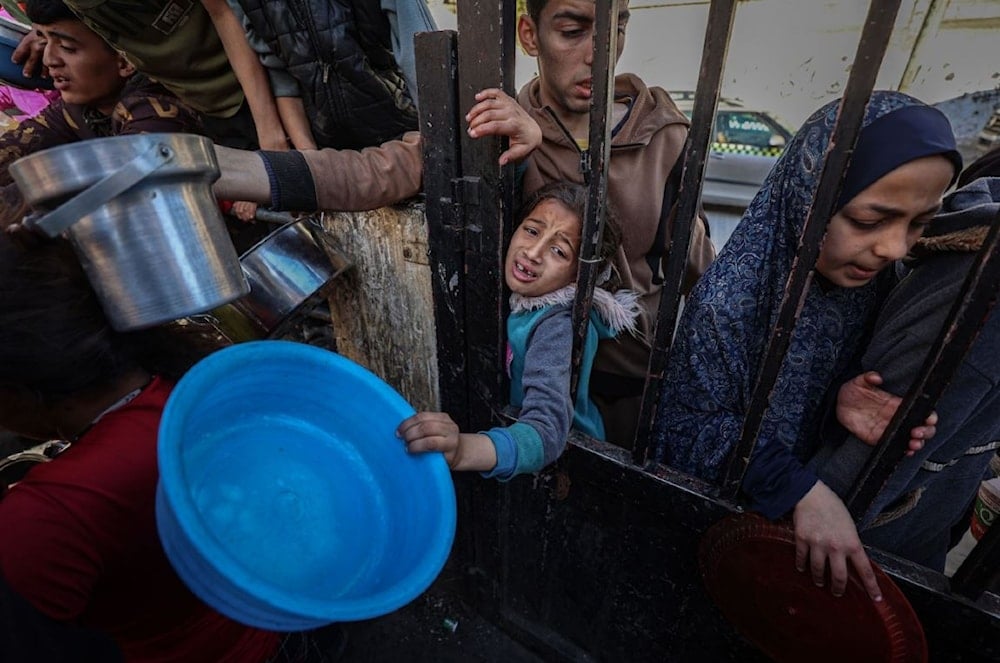 نازحون فلسطينيون يتجمعون لجمع الطعام في رفح جنوبي قطاع غزة - 12 آذار/مارس 2024 (Getty Images) 