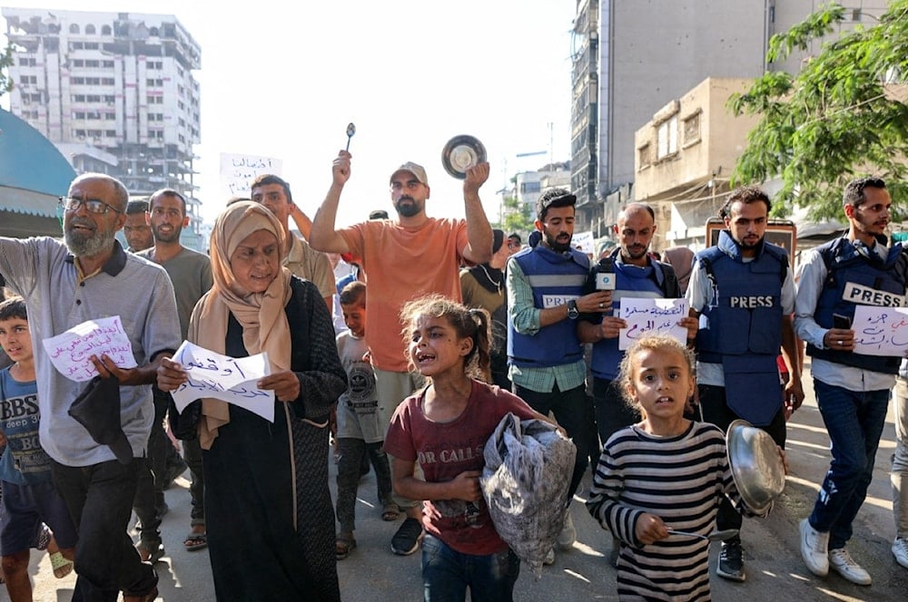 متظاهرون وصحافيون يتظاهرون احتجاجاً على الجوع في حي الرمال في مدينة غزة (AFP)