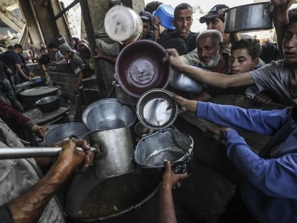 فلسطينيون يحاولون الحصول على وجبة غذاء في ظل تفاقم حرب التجويع التي ينتهجها الاحتلال الإسرائيلي (الأناضول)
