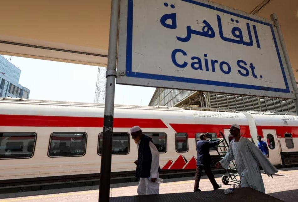 عائلات سودانية تتجمع في محطة القطارات الرئيسية في القاهرة للعودة إلى أسوان في السودان (رويترز)