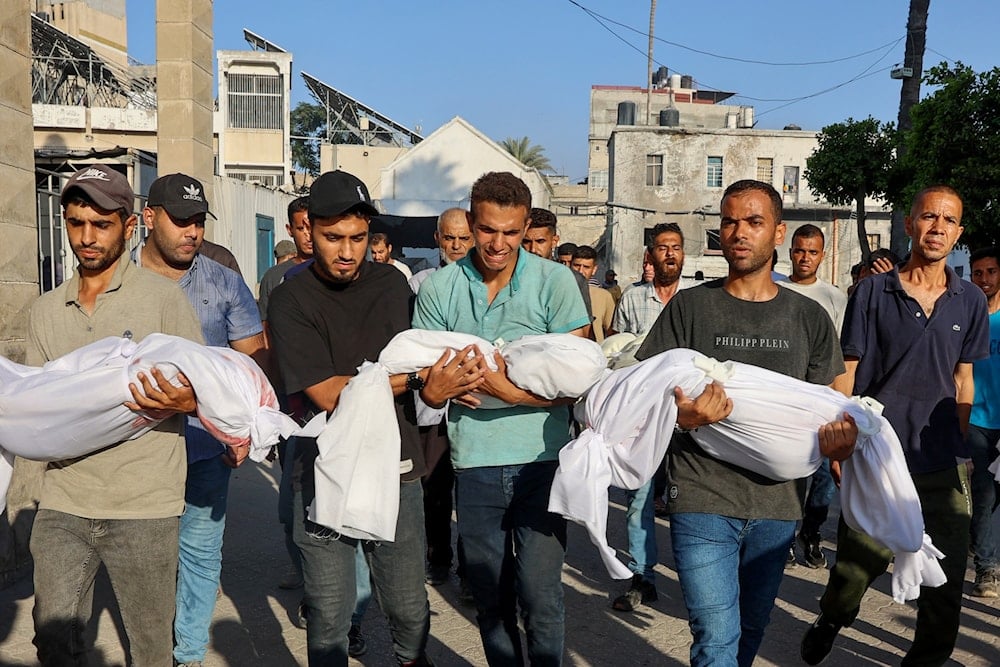 رجال فلسطينيون يحملون جثامين أطفال ارتقوا في غارة إسرائيلية على مدينة غزة - 2 تموز/يوليو 2025 (أ ف ب)