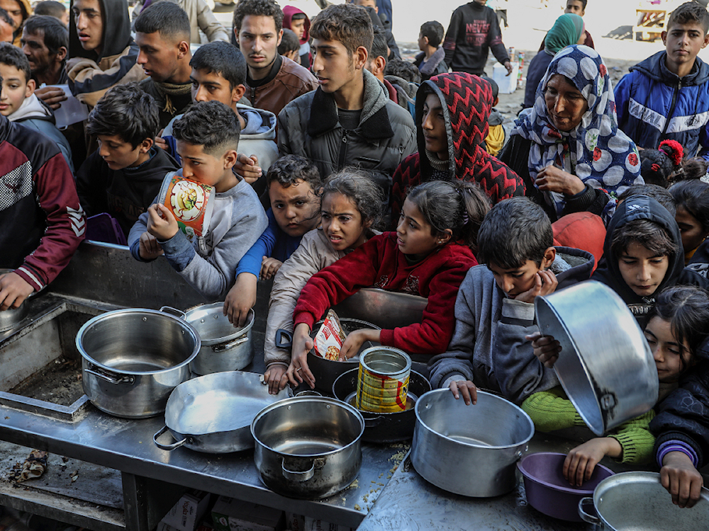 أطفال فلسطينيون ينتظرون الحصول على الغذاء (أرشيفية)