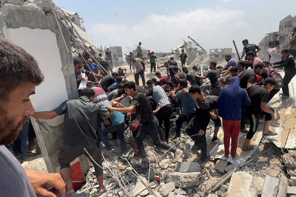 فلسطينيون يتجولون حول طرد إنساني ألقته طائرة عسكرية في جباليا 9 آب/أغسطس 2025 (أ ف ب)