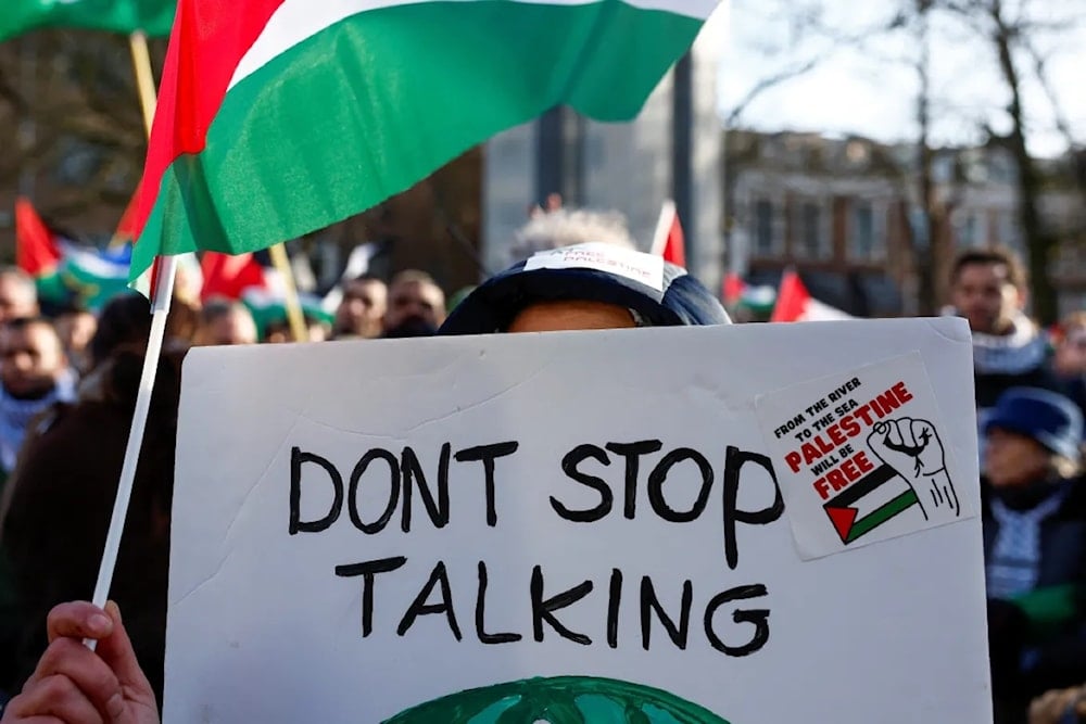 شخص يحمل لافتة خلال مظاهرة مؤيدة للفلسطينيين خارج محكمة العدل الدولية، في لاهاي هولندا-أرشيف (رويترز)