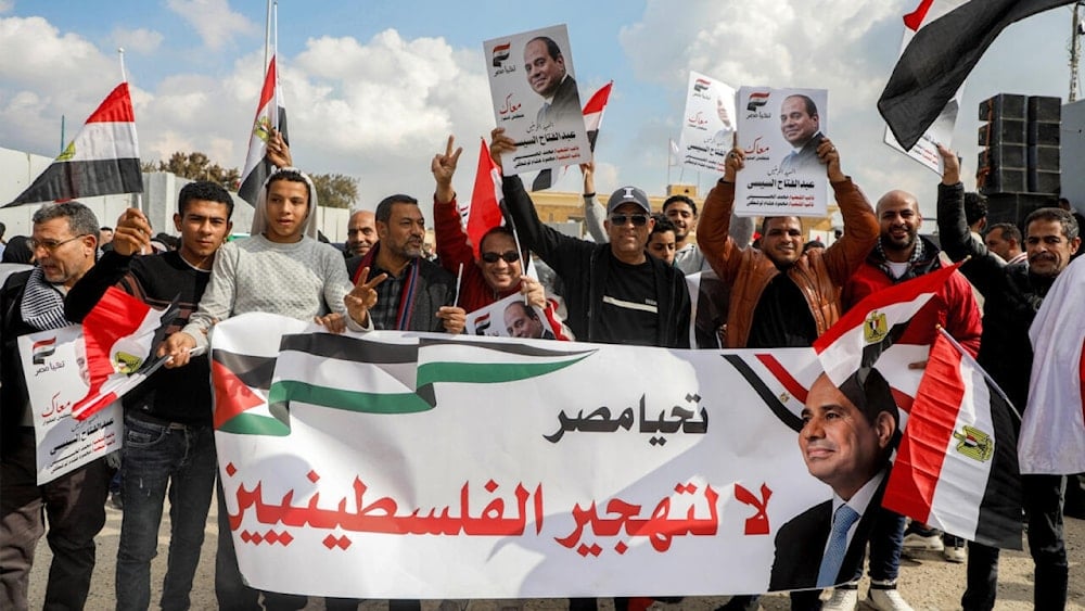 متظاهرون على الجانب المصري من معبر رفح الحدودي مع قطاع غزة في 31 كانون الثاني/يناير 2025 يحتجون على خطة ترامب لتهجير الفلسطينيين إلى مصر والأردن (أ ف ب)