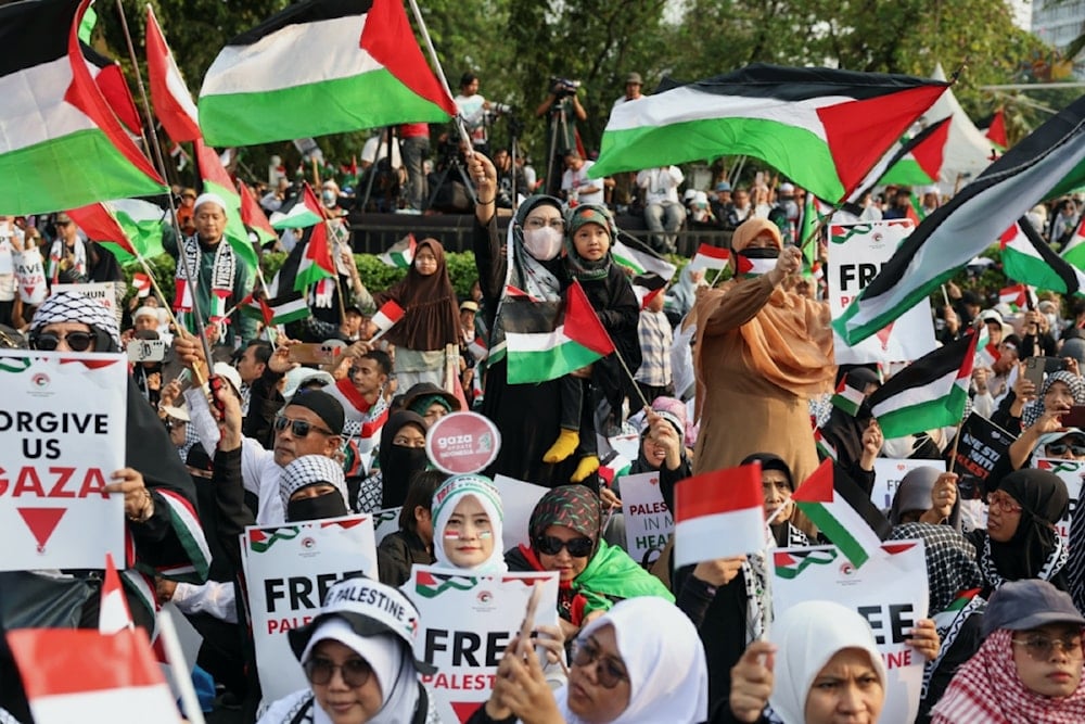 إندونيسيون يرفعون أعلام فلسطين في تظاهرة تطالب بالحرية وبوقف العدوان الإسرائيلي (رويترز)