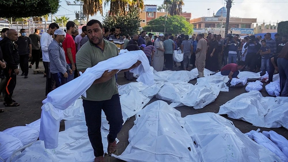 فلسطيني يحمل جثمان شهيد ارتقى في العدوان الاسرائيلي على غزة