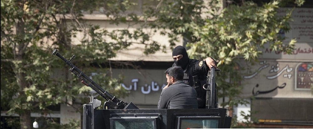 جنديان من القوات الخاصة التابعة للشرطة الإيرانية على متن مركبة مدرعة في العاصمة طهران (أ ف ب)