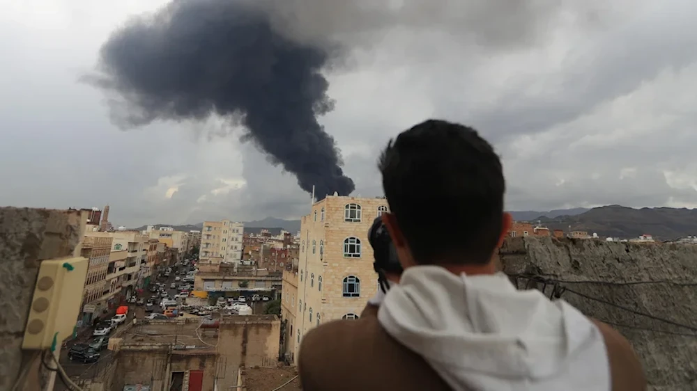 يمني يوثق تصاعد الدخان عقب غارات إسرائيلية على صنعاء، اليمن، 24 آب/أغسطس 2025 (أسوشيتد برس)