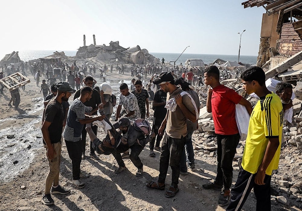 فلسطينيون ينتشلون جثث ضحايا أطلقت قوات الاحتلال النار عليهم أثناء انتظارهم مساعدات إنسانية قرب معبر زيكيم شمالي قطاع غزة 2 آب/أغسطس 2025 (الأناضول)