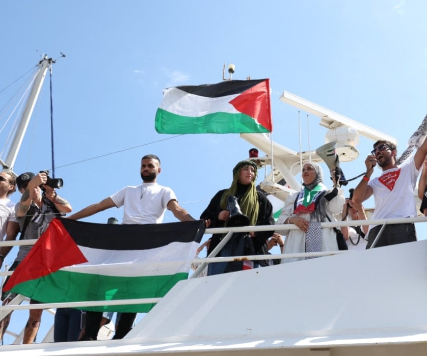 نشطاء يلوحون بالأعلام الفلسطينية قبل انطلاق أسطول الحرية الهادف إلى كسر الحصار الإسرائيلي على قطاع غزة، في برشلونة، في 31 آب/أغسطس 2025 (أ ف ب)