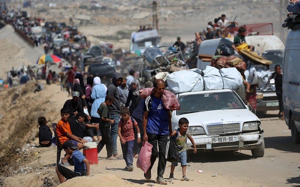 فلسطينيون من مدينة غزة يتجهون جنوباً حاملين أمتعتهم، على الطريق الساحلي قرب مخيم النصيرات للاجئين في وسط قطاع غزة (أ ف ب)