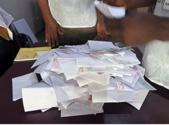 مسؤولو الانتخابات يحصون أوراق الاقتراع في استفتاء على دستور جديد بكوناكري في غينيا (رويترز)