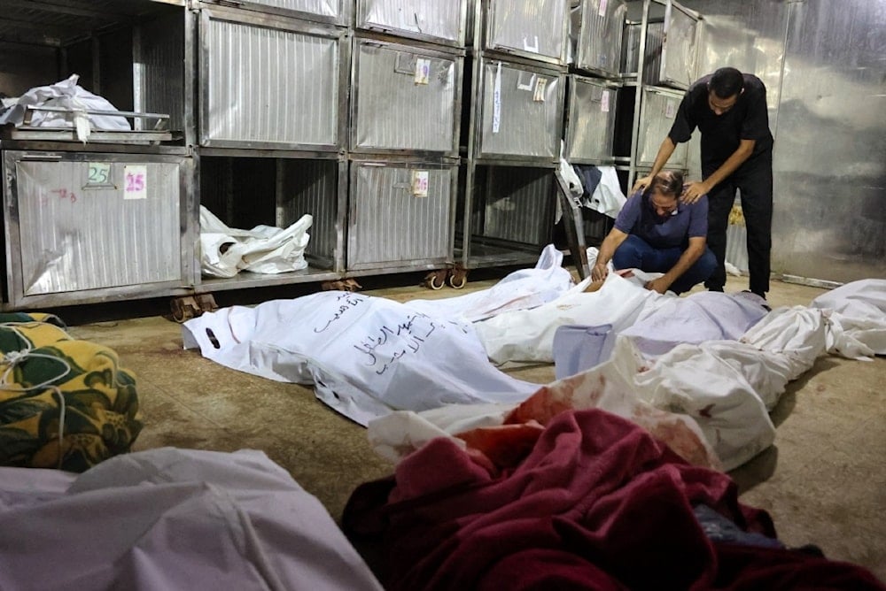 فلسطينيون يحملون جثث الشهداء في الغارات الإسرائيلية على مدينة غزة عند فجر اليوم (أ ف ب)