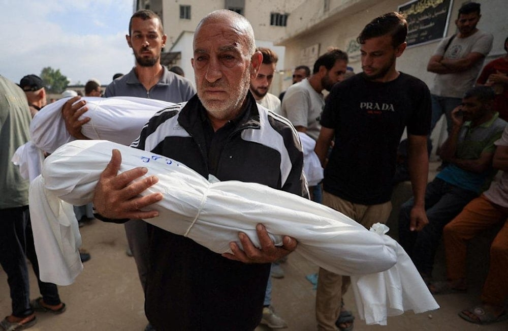 فلسطيني يحمل جثمان طفل استشهد بالقصف الإسرائيلي على غزة (أرشيف)