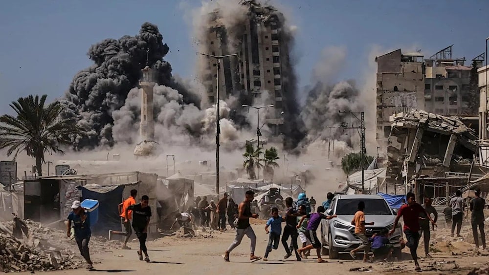 فلسطينيون يركضون في أثناء غارة جوية إسرائيلية على مبنى شاهق في مدينة غزة (أسوشيتد برس)