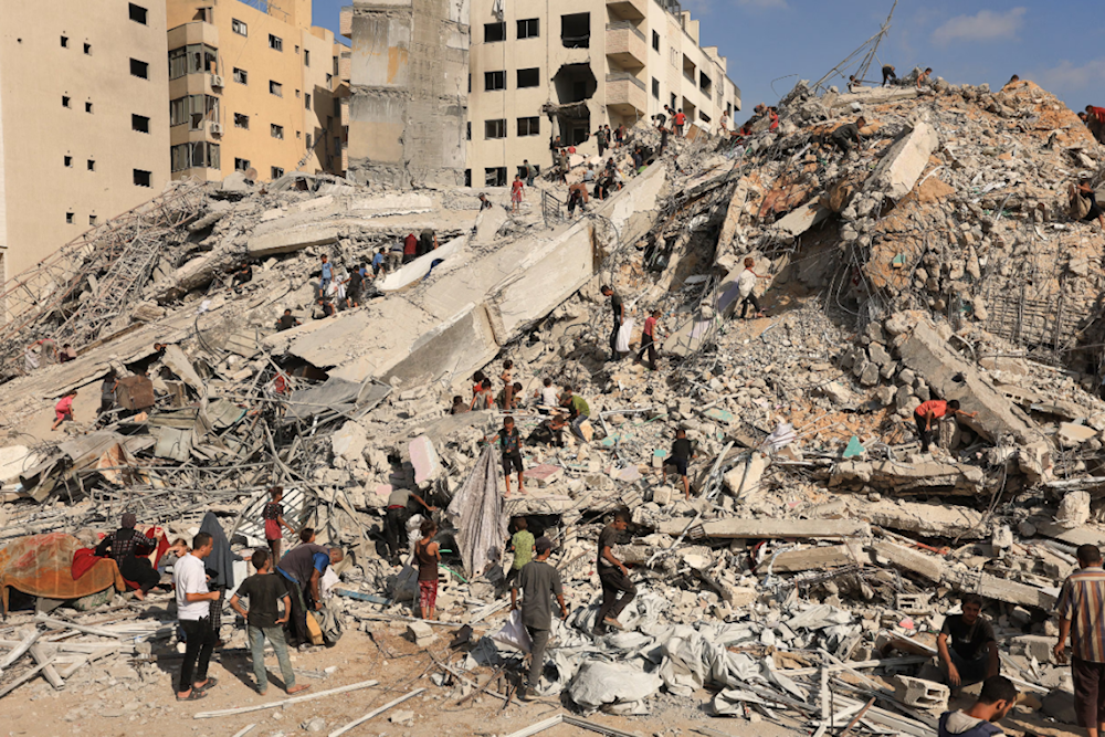 فلسطينيون يتفقدون موقع غارة جوية إسرائيلية دمرت مبنى سكنياً في مدينة غزة (رويترز)